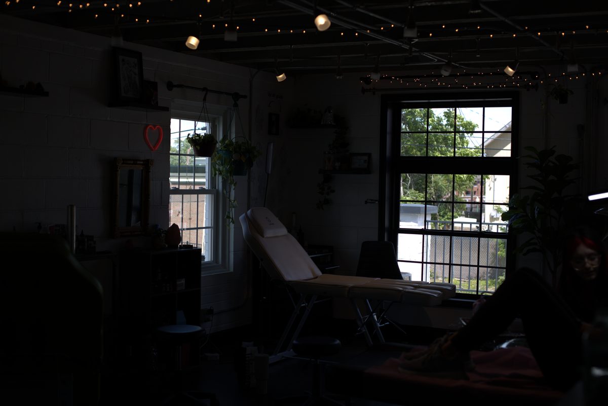 A Dawnbringer booth at dusk — chair, lamp, and brick wall